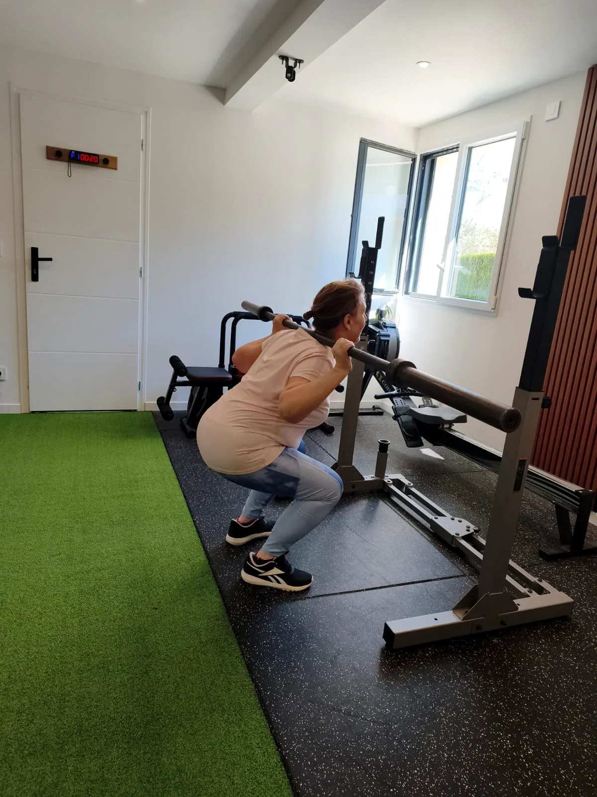 Squat guidé à la barre pendant une séance de coaching au studio STØRM
